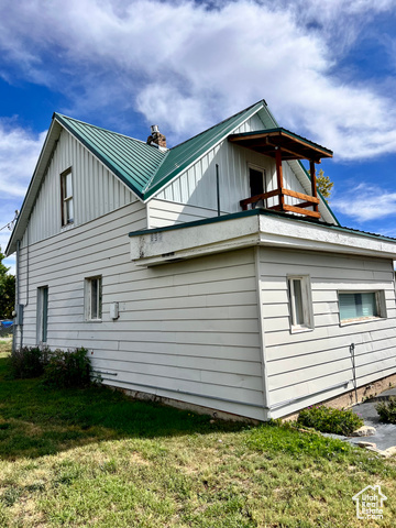 350 West Main Street Emery, UT 84522 - Photo 28 of 28 View of side of home with a balcony, a yard, and board and batten siding