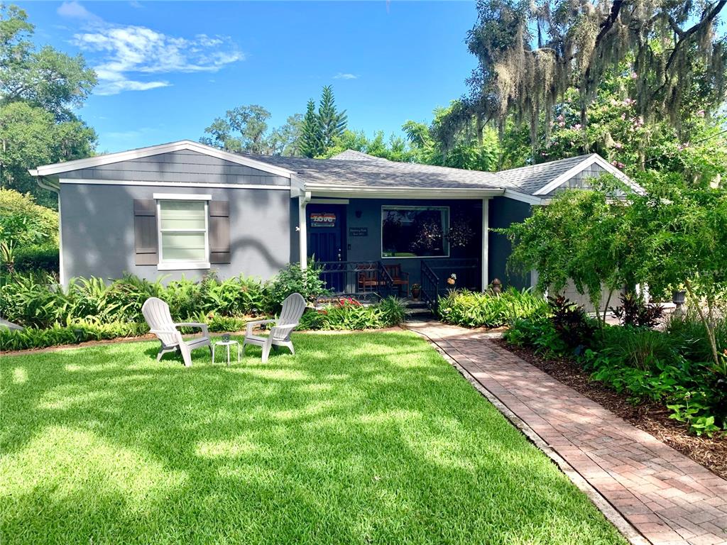 a view of a chair and table in backyard of the house
