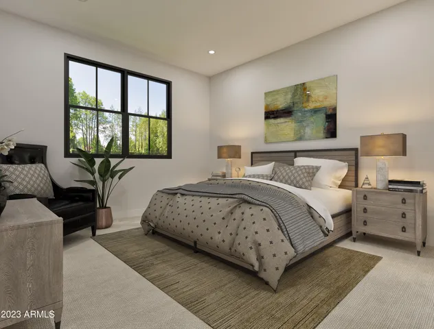 a bedroom with a large bed and windows