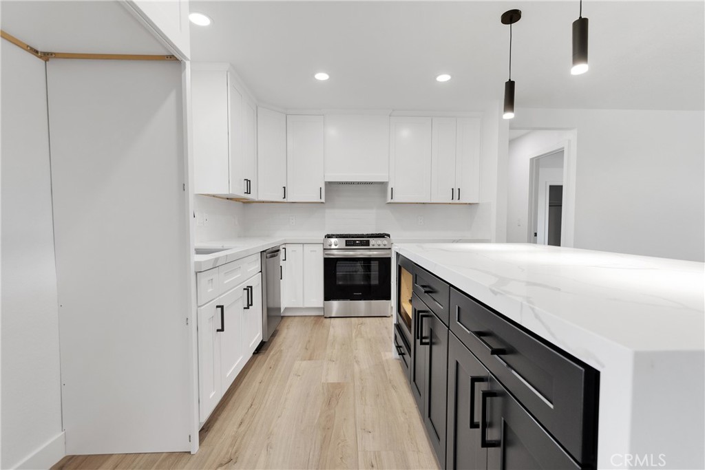 20717 Eyota Apple Valley, CA 92308 - Photo 11 of 38 a kitchen with granite countertop a sink a counter space stainless steel appliances and cabinets