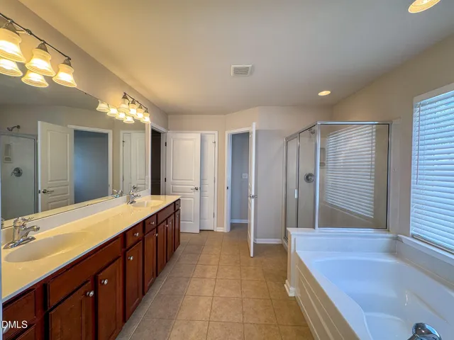 a spacious bathroom with a sink mirror and a bathtub