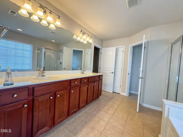 a spacious bathroom with a double vanity sink and a mirror