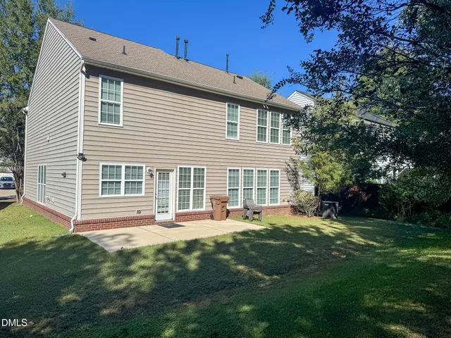 a front view of a house with a yard and trees