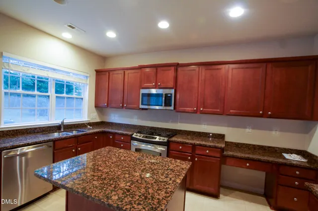a kitchen with granite countertop wooden cabinets and a sink