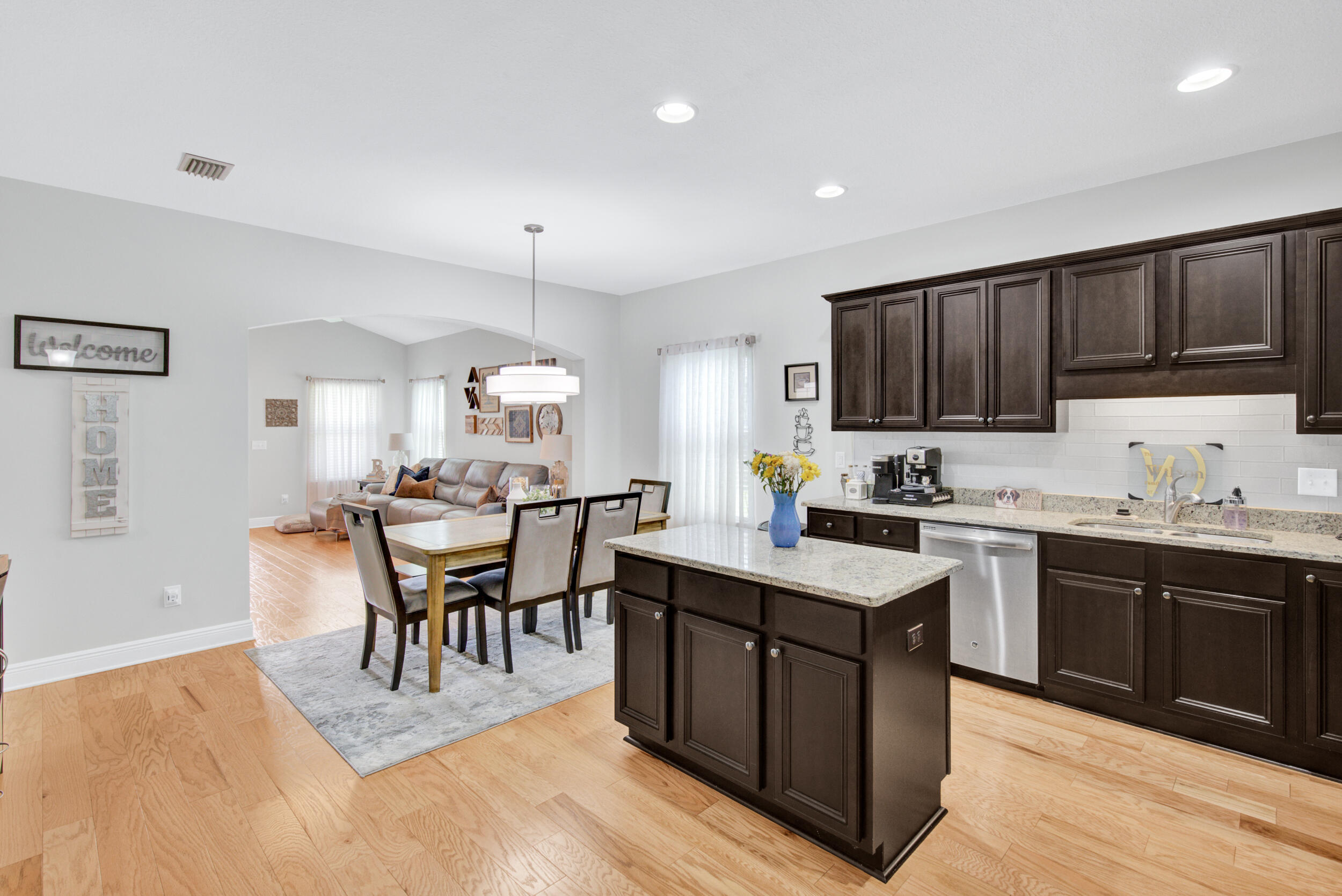 340 Pin Oak Loop Santa Rosa Beach, FL 32459 - Photo 15 of 52 a kitchen with stainless steel appliances granite countertop a stove top oven a sink dishwasher a dining table and chairs with wooden floor