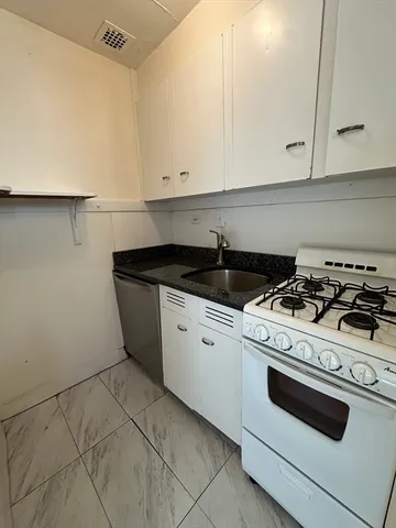 a white stove top oven sitting inside of a kitchen
