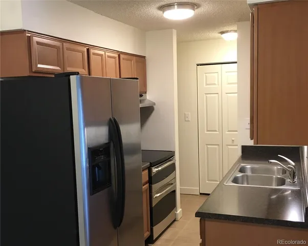 a kitchen with stainless steel appliances granite countertop a refrigerator and a sink