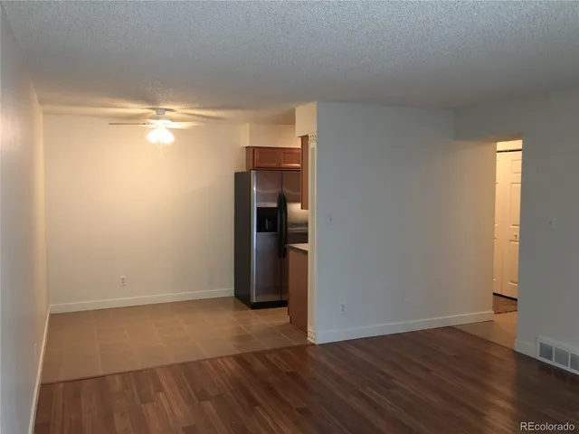 a view of empty room with wooden floor and window