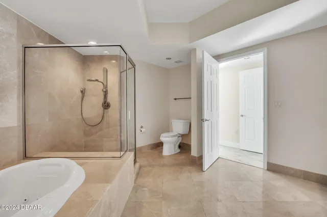 a bathroom with a granite countertop bathtub shower and toilet