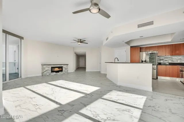 a view of a kitchen with kitchen island a sink stainless steel appliances and cabinets