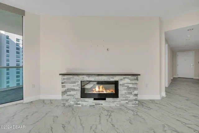 an empty room with wooden floor and a fireplace