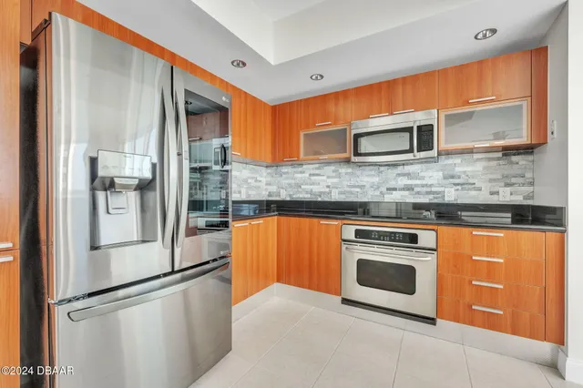 a kitchen with stainless steel appliances granite countertop a refrigerator and a sink