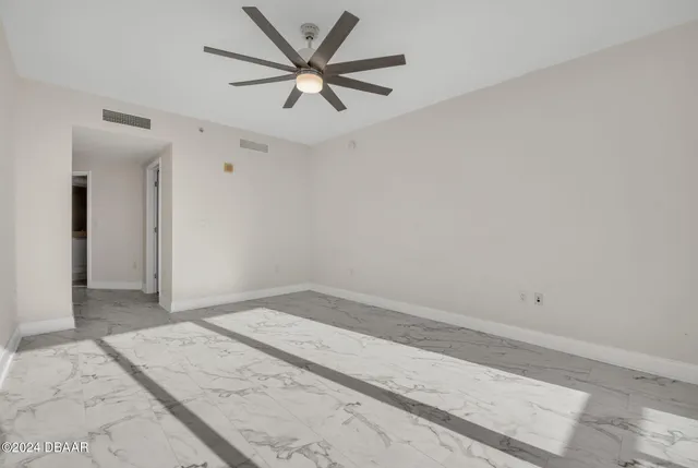 an empty room with a ceiling fan and a window