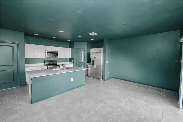a open kitchen with kitchen island a sink stainless steel appliances and cabinets