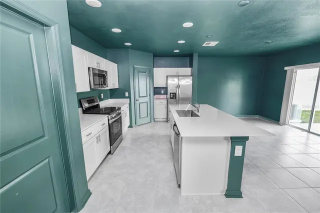 a kitchen with kitchen island a sink appliances and cabinets