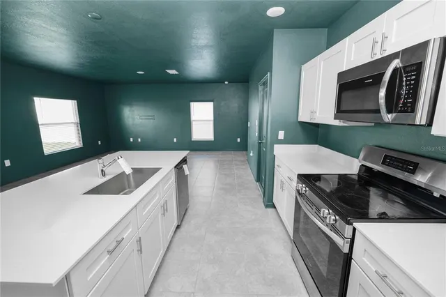 a kitchen with a sink a microwave and cabinets