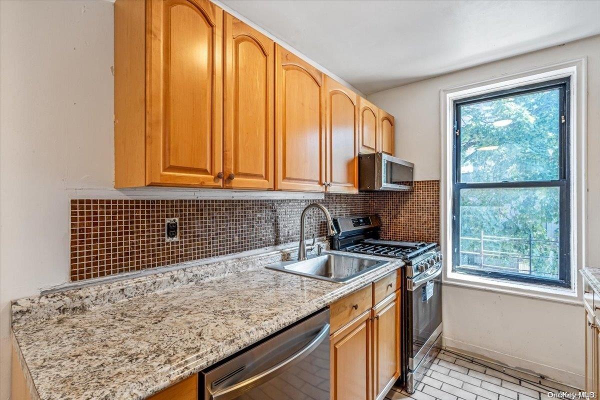2860 Bailey Avenue, Unit 4F Bronx, NY 10463 - Photo 12 of 19 a kitchen with granite countertop a sink and a window