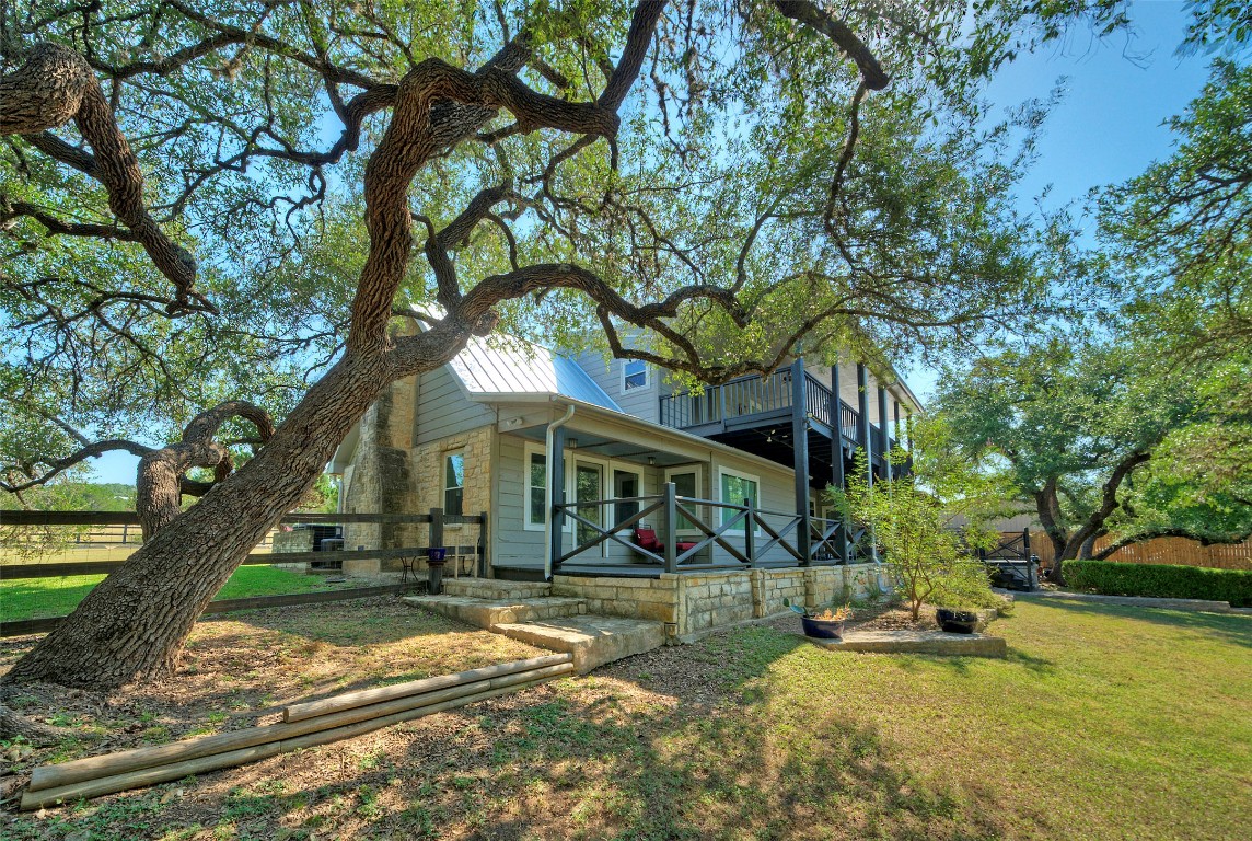 101 Arrowlake Road Wimberley, TX 78676 - Photo 13 of 40 a view of a white house with a big yard and large tree