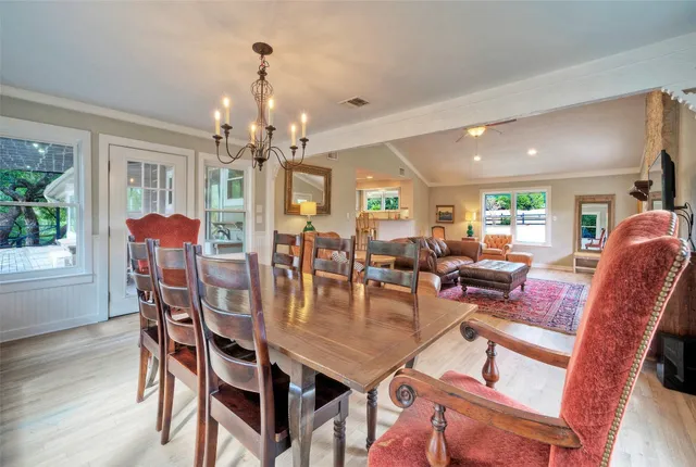 a living room with stainless steel appliances furniture a fireplace and a open kitchen view