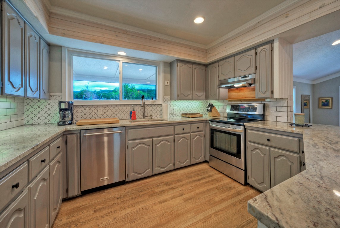 101 Arrowlake Road Wimberley, TX 78676 - Photo 25 of 40 a kitchen with kitchen island granite countertop a sink cabinets and stainless steel appliances