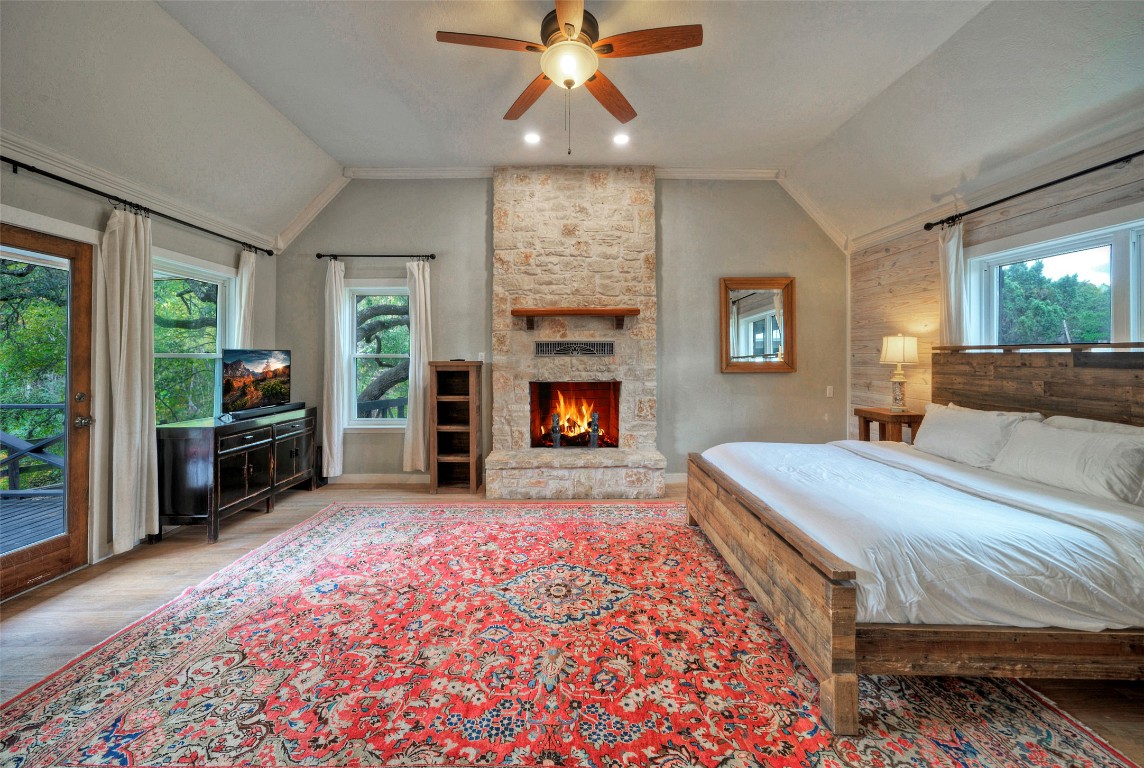 101 Arrowlake Road Wimberley, TX 78676 - Photo 26 of 40 a spacious bedroom with a bed and a fireplace