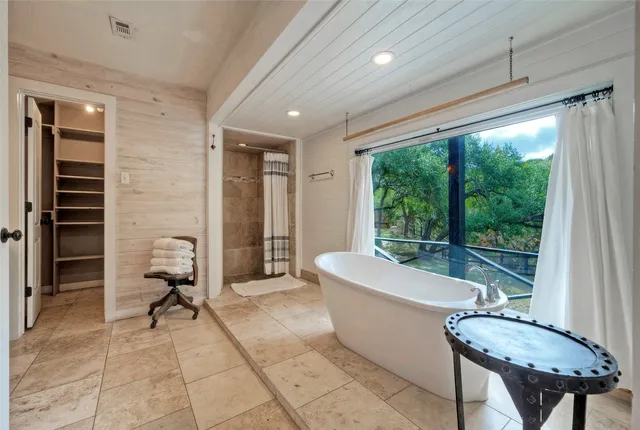 a spacious bathroom with a granite countertop tub sink and mirror