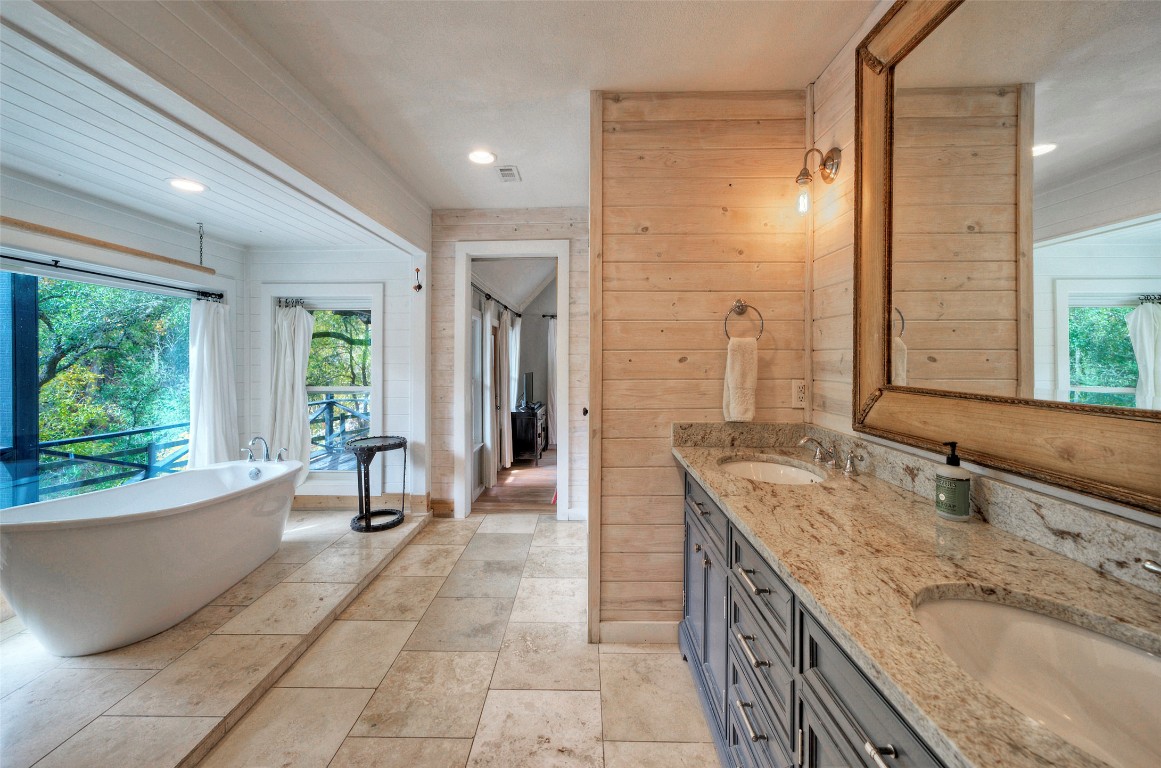 101 Arrowlake Road Wimberley, TX 78676 - Photo 29 of 40 a spacious bathroom with a granite countertop tub sink and mirror