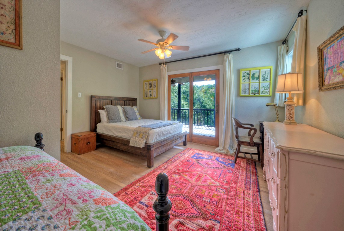 101 Arrowlake Road Wimberley, TX 78676 - Photo 32 of 40 a bedroom with a bed and a chandelier