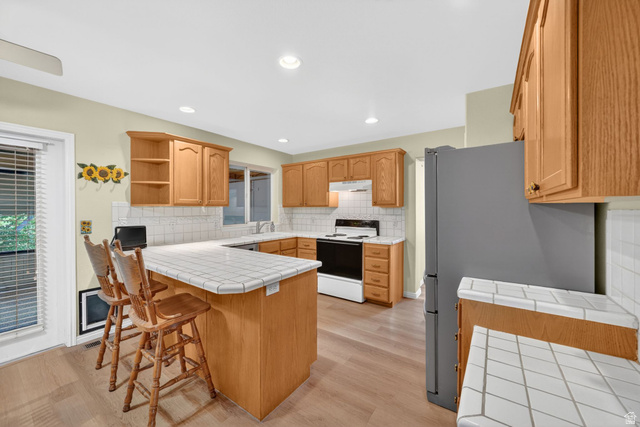 1464 990 West Provo, UT 84601 - Photo 11 of 41 Kitchen featuring wood-finish flooring, light wood cabinetry, and a tile countertop