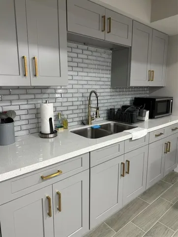 a kitchen with white cabinets a sink a stove and dishwasher