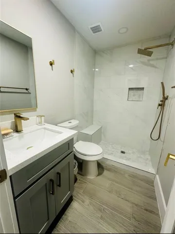 a bathroom with a sink a toilet and shower