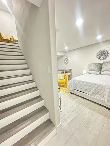 a bedroom with a bed and a view of entryway