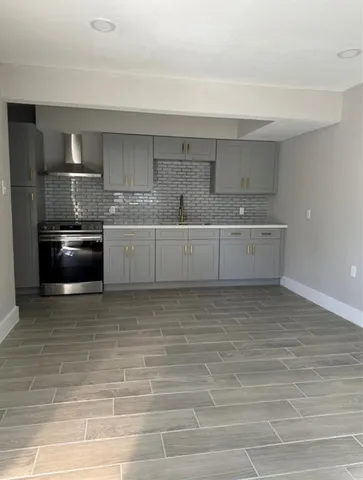 a large kitchen with stainless steel appliances granite countertop a sink stove and cabinets