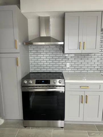 a stove top oven sitting inside of a kitchen
