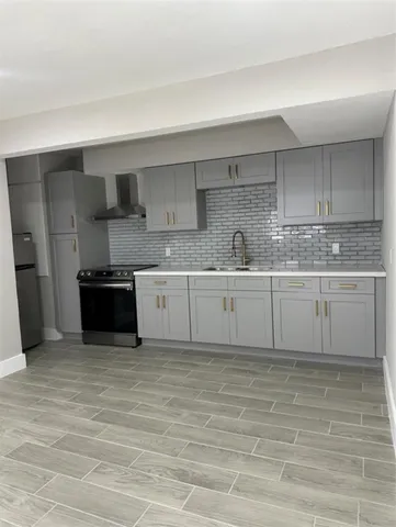 a kitchen with stainless steel appliances granite countertop a sink a stove and a refrigerator