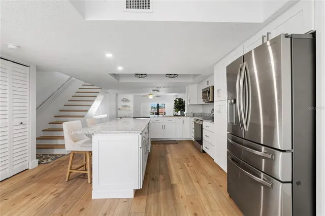 a kitchen with granite countertop white cabinets and white appliances