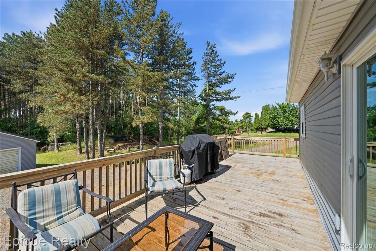 12272 East Mt Morris Road Davison, MI 48423 - Photo 28 of 39 Spacious outdoor deck with natural wood railing overlooking mature trees
