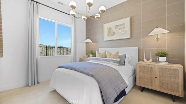 a bedroom with a bed chandelier and a window