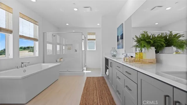 a spacious bathroom with a double vanity sink a large mirror and shower