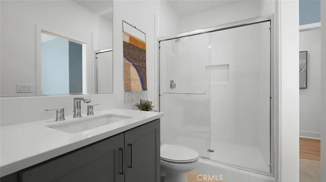 a bathroom with a shower sink vanity mirror and toilet