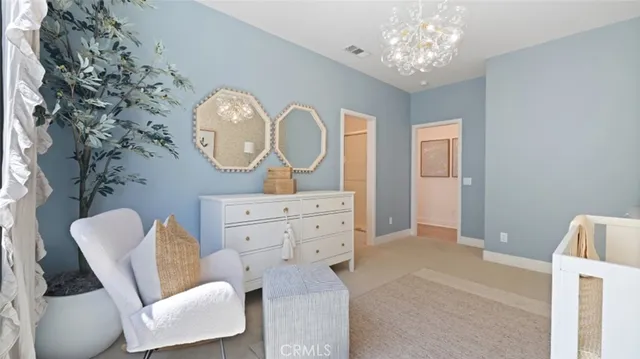 a living room with furniture a mirror and a fan