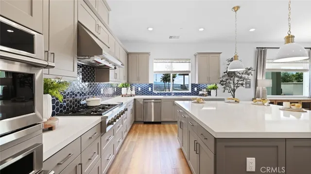 a kitchen with kitchen island a counter top space a sink stainless steel appliances and cabinets