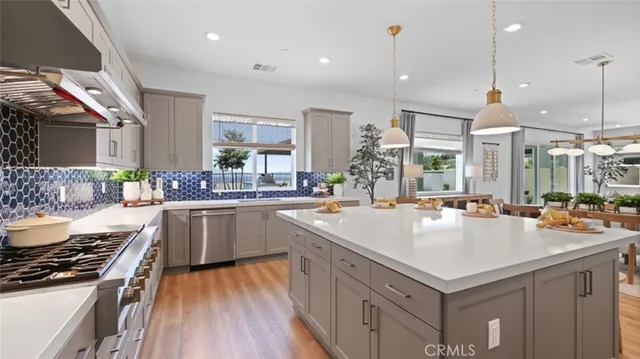 a kitchen with sink a stove and chairs