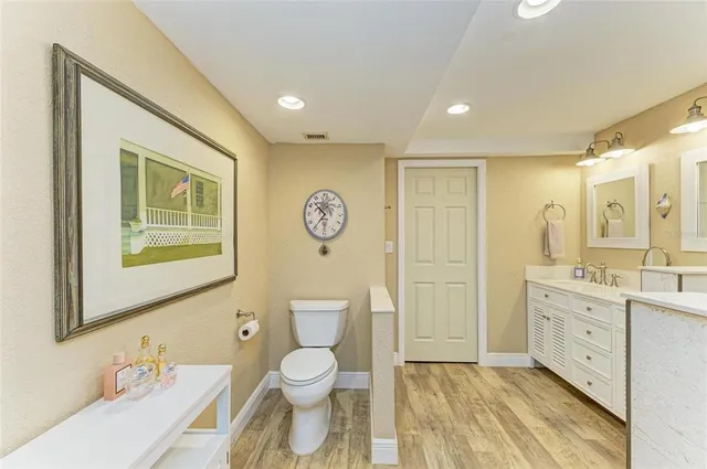 a bathroom with a granite countertop toilet sink and mirror