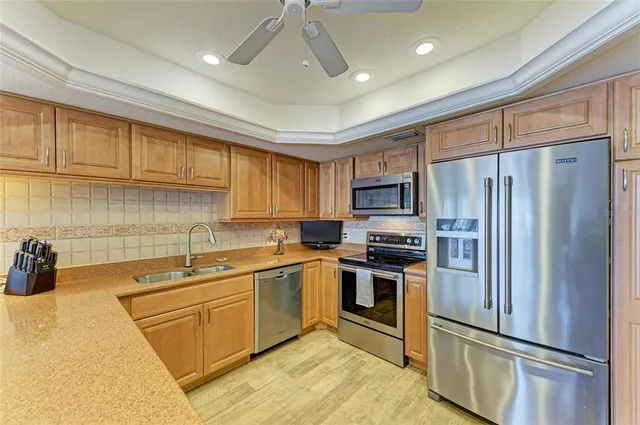 a kitchen with stainless steel appliances a refrigerator sink and microwave