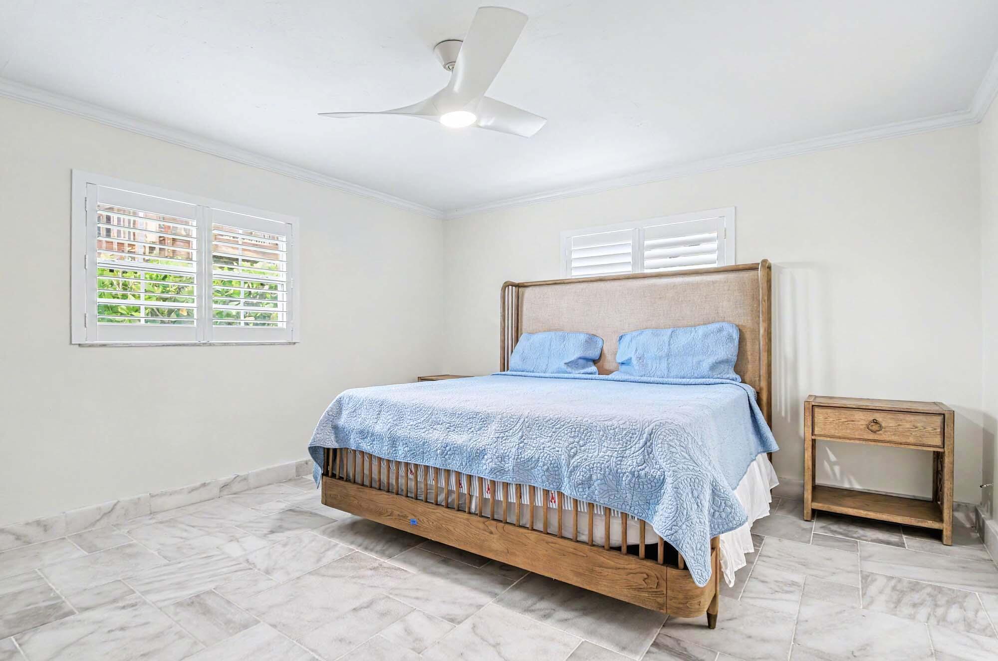 112 Capri Boulevard Naples, FL 34113 - Photo 18 of 29 a bedroom with a bed and a chandelier