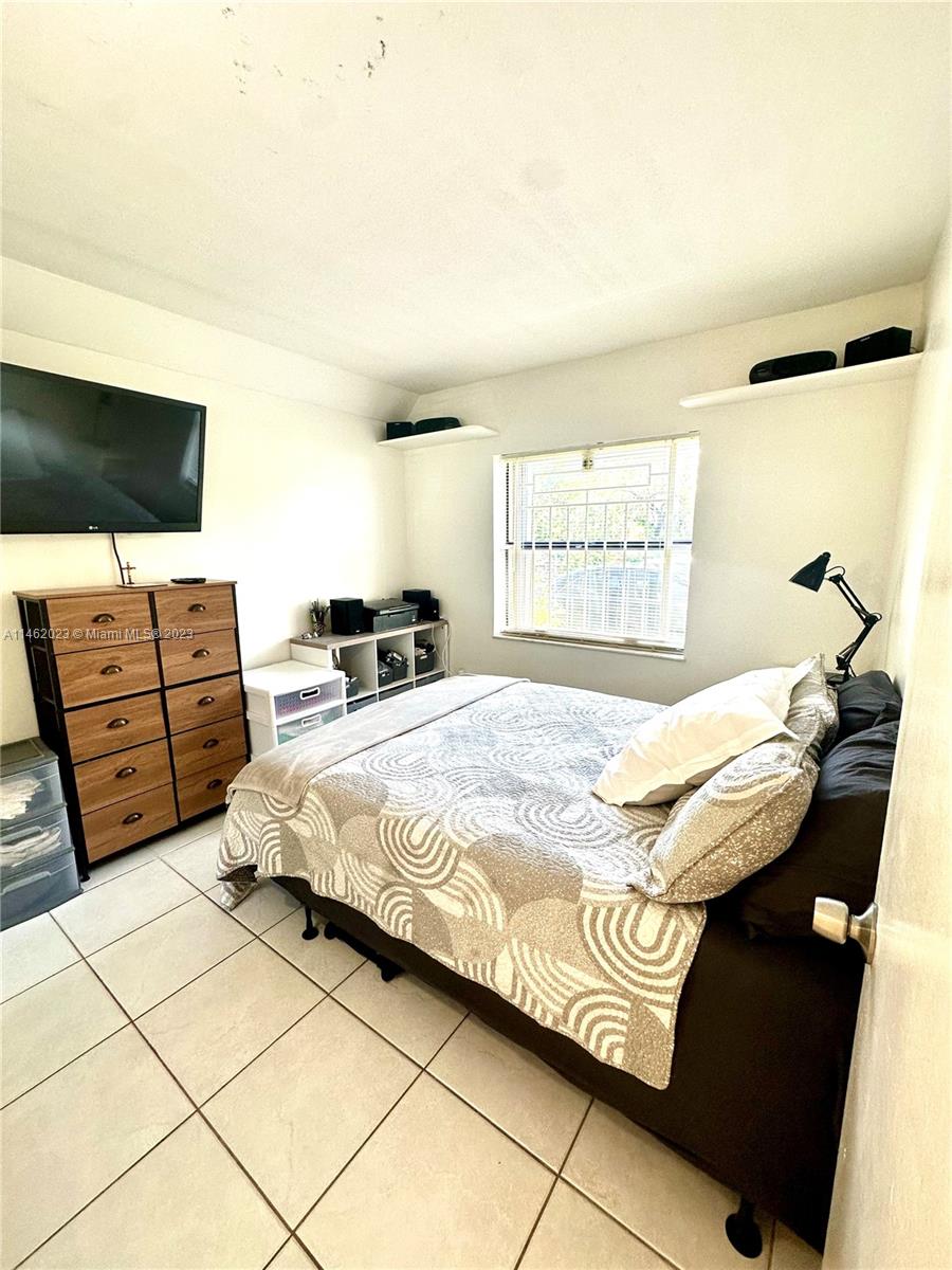 2580 West 67th Place, Unit 1011 Hialeah, FL 33016 - Photo 17 of 23 a bedroom with a bed and flat screen tv