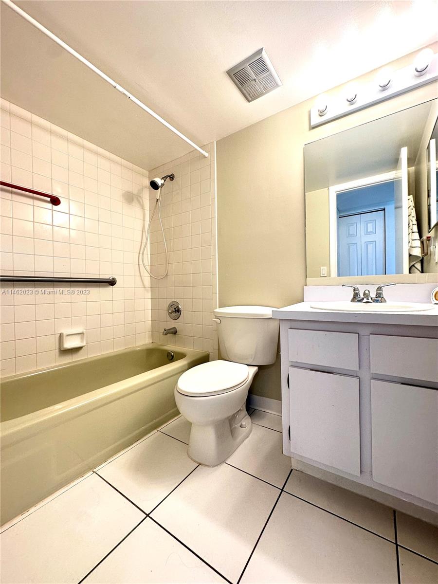 2580 West 67th Place, Unit 1011 Hialeah, FL 33016 - Photo 18 of 23 a bathroom with a toilet a sink a mirror and bathtub
