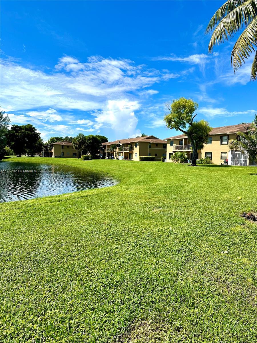 2580 West 67th Place, Unit 1011 Hialeah, FL 33016 - Photo 23 of 23 a view of a garden with a building in the background