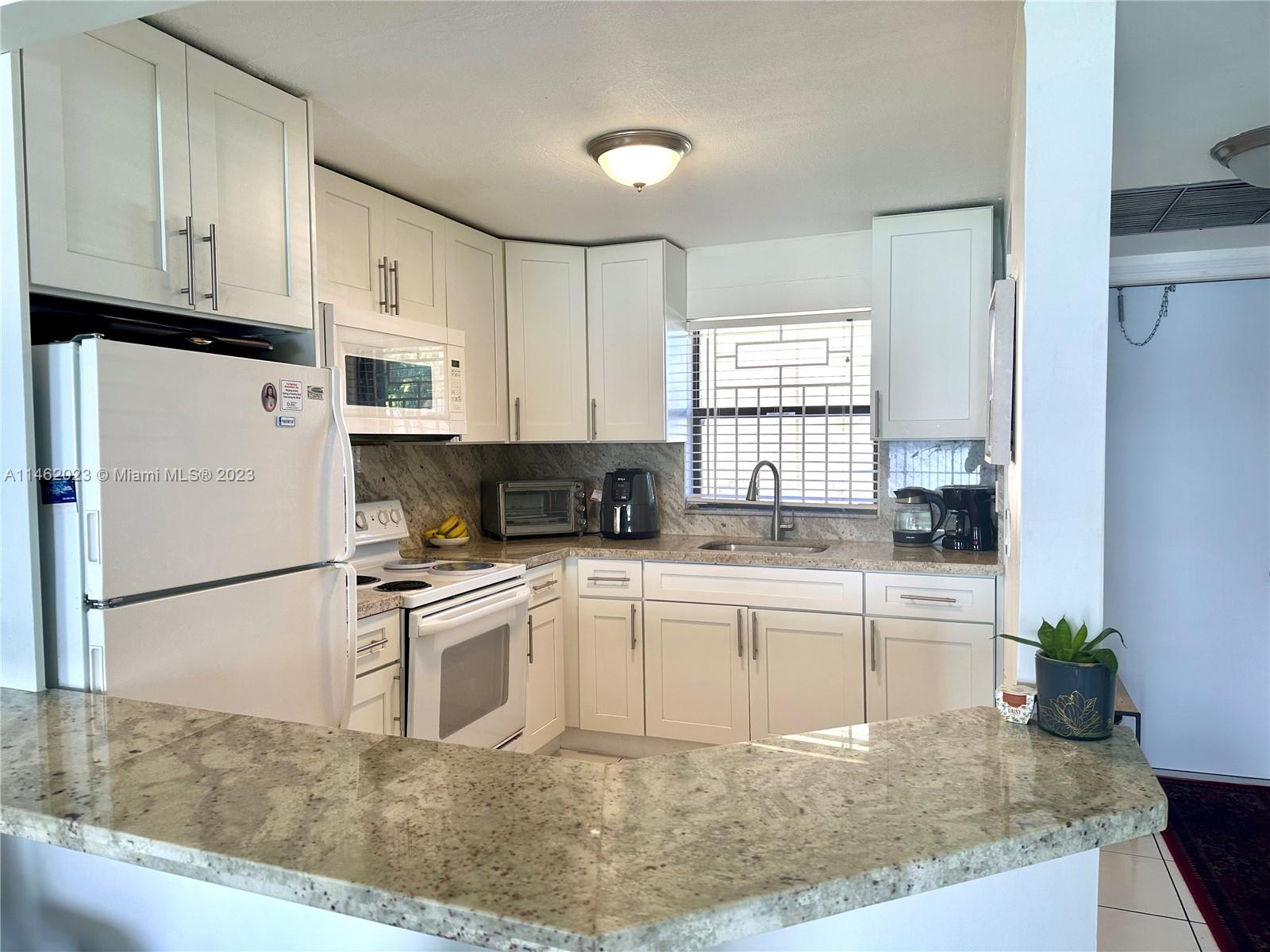 2580 West 67th Place, Unit 1011 Hialeah, FL 33016 - Photo 3 of 23 a kitchen with stainless steel appliances granite countertop a refrigerator sink stove and white cabinets
